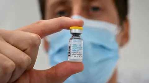 Getty Images Scientist holding a vial of vaccine against mpox