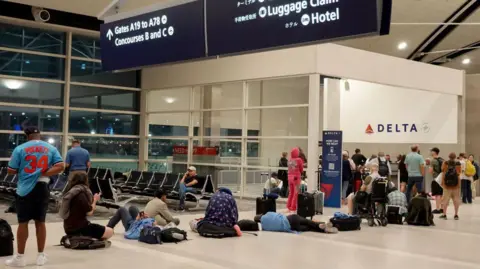 Getty Images Tired passengers at an airport in Detroit