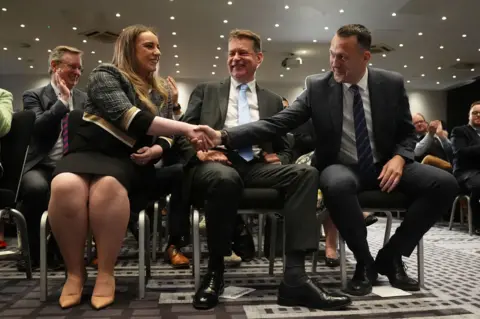 PA Media Russell Findlay shakes hands with defeated candidate Meghan Gallacher after the result is announced