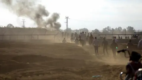 Reuters Palestinians run towards breached fence between Gaza and Israel (07/10/24)