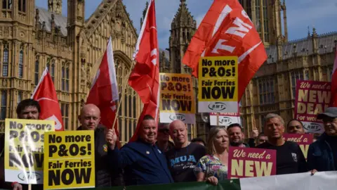 Getty Images Protestors outside Parliament holding placards criticising the employment practices of P&O ferries.