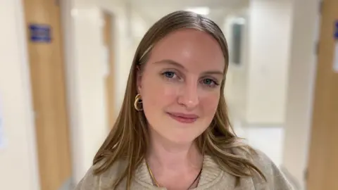 BBC Picture of Eliza standing in a hospital corridor