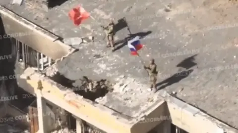 Russian social media Pro-Kremlin military bloggers have posted images showing Russian flags flying over ruined buildings