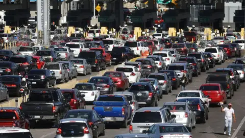 Getty Images Cars queuing to enter the US from Mexico