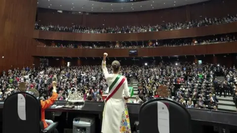 Reuters Mexico's new President Claudia Sheinbaum raises her fist as she delivers a speech during her swearing-in ceremony at the Congress in Mexico City, Mexico, October 1, 2024