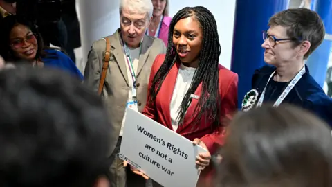 Getty Images Kemi Badenoch at the 2024 Conservative conference, holding a placard reading 'Women's rights are not a culture war'