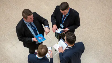 Getty Images Four men in discussion at the Conservative Party Conference in Birmingham last week