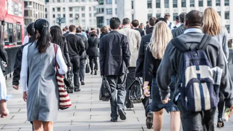 Getty Images Picture of many commuters walking towards office buildings