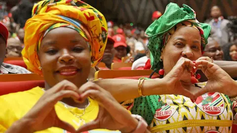 AFP Supporters of the presidential Frelimo candidate Daniel Chapo make love heart gestures at electoral meeting in Maputo - 2 October 2024