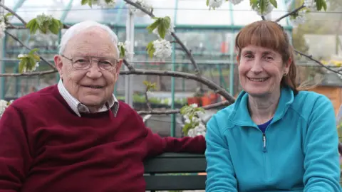 Tern TV Jim McColl and Carole Baxter on a bench, smiling