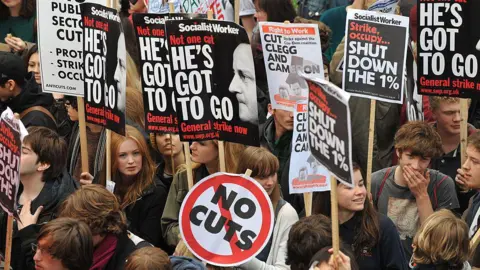 Getty Images Student demonstrators carry banners as they march against cuts in tuition funding in London on 9 November 2011