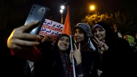 Getty Images Iranian women celebrate on the streets of Tehran