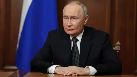 Reuters Russian President Vladimir Putin sits at his desk delivering an address to Russians on TV