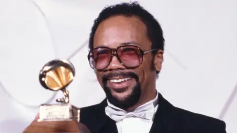 Getty Images Quincy Jones holding up a Grammy Award in 1982