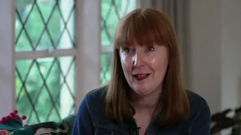 Elise Burns facing towards the camera. She is dressed in a denim top and has light brown hair.