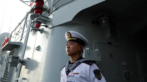 Reuters A member of the Chinese People's Liberation Army (PLA) Navy stands guard on the Shijiazhuang, a Type 051C guided-missile destroyer, as the Navy opens warships for public viewing to mark its upcoming 75th founding anniversary, at the port in Qingdao, Shandong province, China 20 April 2024