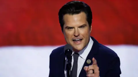 Getty Images A close up of Matt Gaetz on stage at the Republican convention in Milwaukee, Wisconsin in July. He is speaking into a microphone and is pointing with his hand. He has dark brown hair and wears a dark suit, white shirt and navy tie.