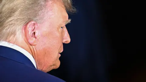 Getty Images Image shows a side profile of Donald Trump in front of a black background