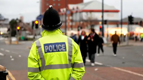 Getty Images A police officer stands by a road in a town centre