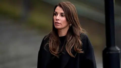 PA Media Coleen Rooney wearing a black coat