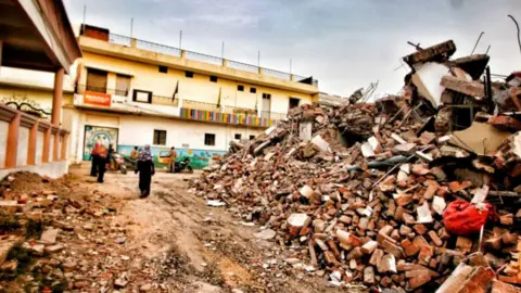 Vivek Singh People standing outside Javed Mohammad's home in India's Uttar Pradesh state after it was demolished