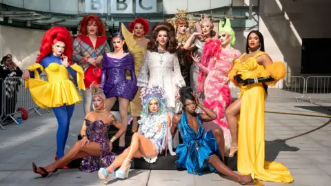 BBC / World Of Wonder / Kieron McCarron The 12 series six queens from Ru Paul's Drag Race UK pictured together outside the BBC's New Broadcasting House on a sunny day. 