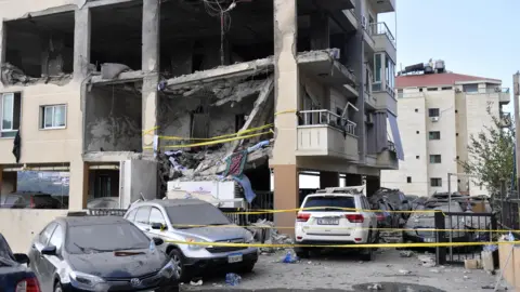 EPA Damaged multi-storey residential building and cars following an Israeli air strike in Aramoun, Lebanon (13 November 2024)