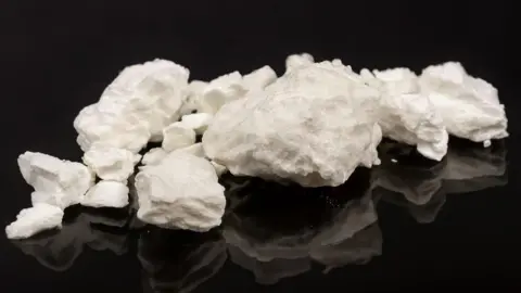 Getty Images An image of crack cocaine - a white rock/rubble shaped drug laid out on a black table 