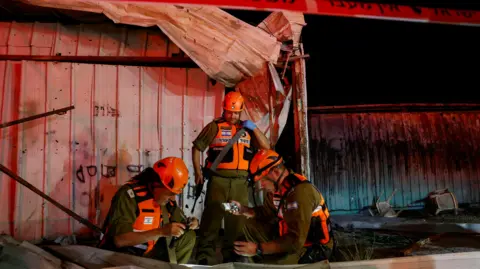 Reuters Israeli security personnel investigate the scene of a deadly Hezbollah rocket attack in Nahariya, northern Israel (12 November 2024)