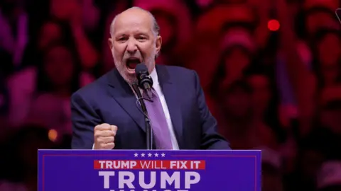 Reuters Howard Lutnick, Chairman and CEO of Cantor Fitzgerald, clenches his fist as he speaks during a rally for Republican presidential nominee and former U.S. President Donald Trump at Madison Square Garden, in New York, U.S., October 27, 2024. 