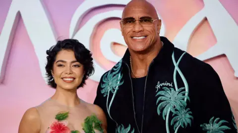 Getty Images US actress Auli'i Cravalho (L) and US actor Dwayne Johnson pose on the red carpet upon arrival for the UK Premier of 