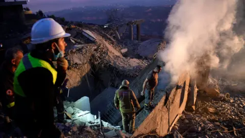 EPA Lebanese first responders search for survivors amid the rubble of a home destroyed in an Israeli air strike, near Baalchmay, central Lebanon (12 November 2024)