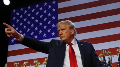 Reuters Donald Trump points to the crowd during his rally, with the backdrop of the US flag