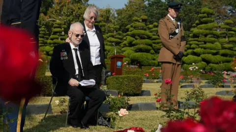 BBC Michael Northey sits by his father's grave