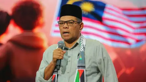 Getty Images Saifuddin Nasution Ismail, holding a microphone, speaking at an event