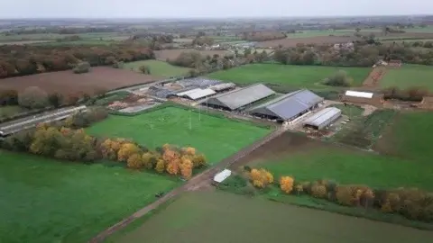 BBC/Shaun Whitmore Aerial picture of three milking barns in the countryside surrounded by fields 