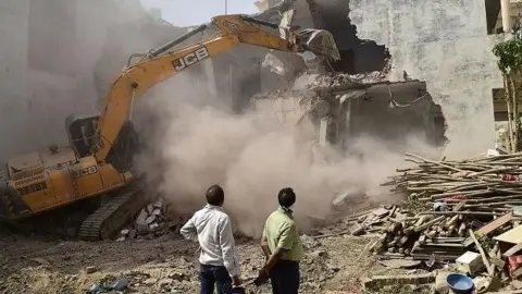 Getty Images A bulldozer is being used to demolish the illegal structures of the residence of Javed Ahmed, a local leader who was allegedly involved in the recent violent protests against Bharatiya Janata Party (BJP) former spokeswoman Nupur Sharma's incendiary remarks about Prophet Mohammed, in Allahabad on June 12, 2022. 