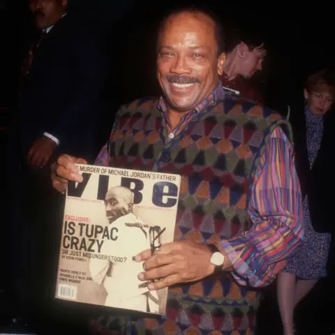 Alamy Quincy Jones holding up a copy of Vibe magazine with Tupac Shakur on the cover and the headline 