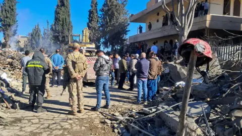 Reuters People and emergency workers gathered outside the site of an Israeli air strike at an emergency response centre