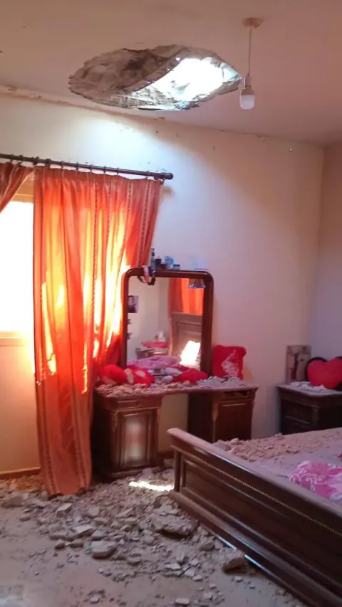 Rasha Makhbour Rubble lies on bedroom furniture beneath a hole in a ceiling at Rasha Makhbour's home, in Rmeish, southern Lebanon