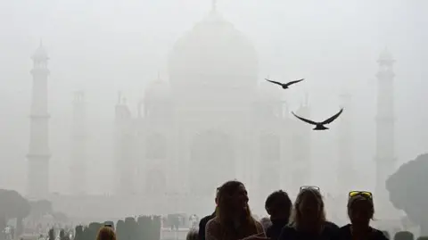 Getty Images Tourists visit the Taj Mahal on a cold smoggy morning in Agra on November 18, 2024