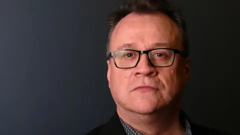 Getty Images Doctor Who showrunner Russell T Davies wears spectacles against a dark background