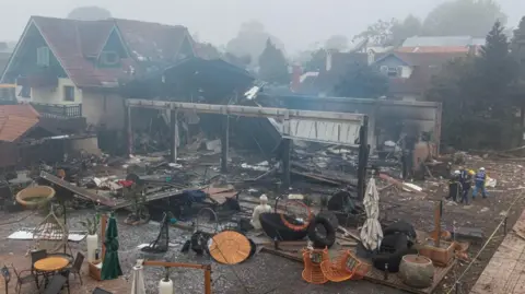 Reuters A damaged building and several wrecked tables and chairs.