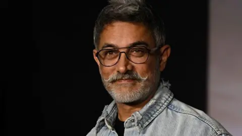 Getty Images Bollywood actor Aamir Khan posing for a picture during a screening