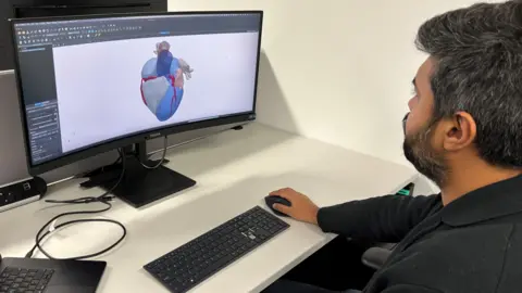 Adsilico An Adsilico researcher looks at a digital twin of a heart