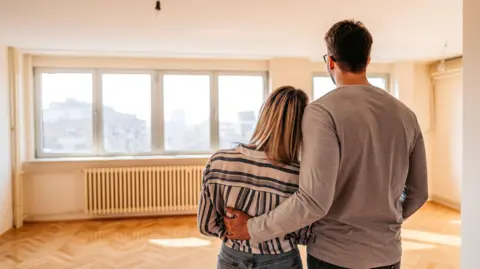 Getty Images Couple looking round a house with no furniture in it