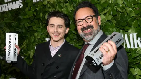 Getty Images Timothée Chalamet, James Mangold pose with their Visionary Tribute awards for 