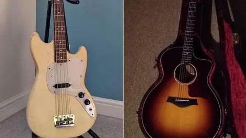 Tom A Smith View of two guitars. The one on the right is a beige-coloured bass guitar on a stand, the one on the left is a brown acoustic guitar in an open case with red velvet lining