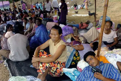 Getty Images Indian villagers rest at a relief camp in the capital of India's Andaman and Nicobar Islands, Port Blair, 31 December 2004. Indian survivors of the tsunami waves are desperately trying to trace missing relatives on the Andamans islands as relief workers struggled to piece together families parted in the ordeal. 