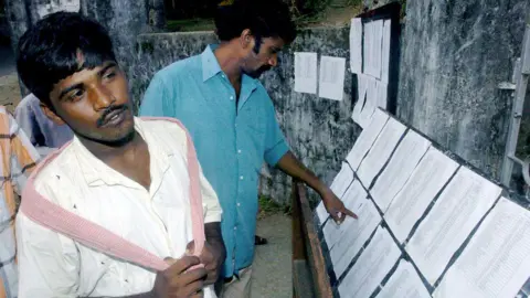 Getty Images Indian villagers check lists of missing persons at a relief camp in the capital of India's Andaman and Nicobar Islands, Port Blair, 31 December 2004. Indian survivors of the tsunami waves are desperately trying to trace missing relatives on the Andamans islands as relief workers struggled to piece together families parted in the ordeal.